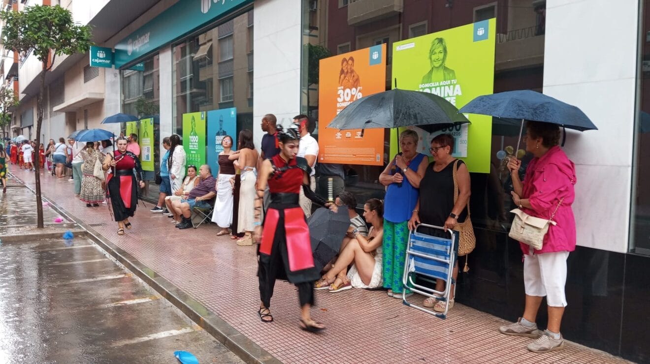 Falleros resguardándose de la lluvia