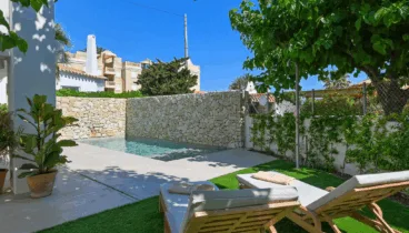 Piscina privada rodeada de terraza con tumbonas