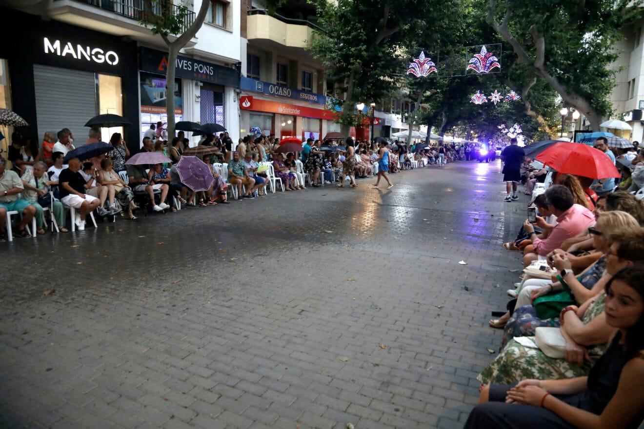 Público aguardando bajo la lluvia al desfile de carrozas y comparsas 2025 de Dénia