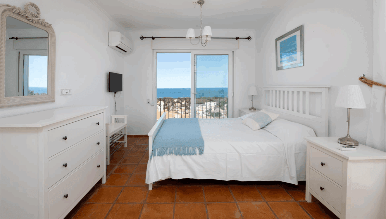 Dormitorio con cama doble junto a la piscina