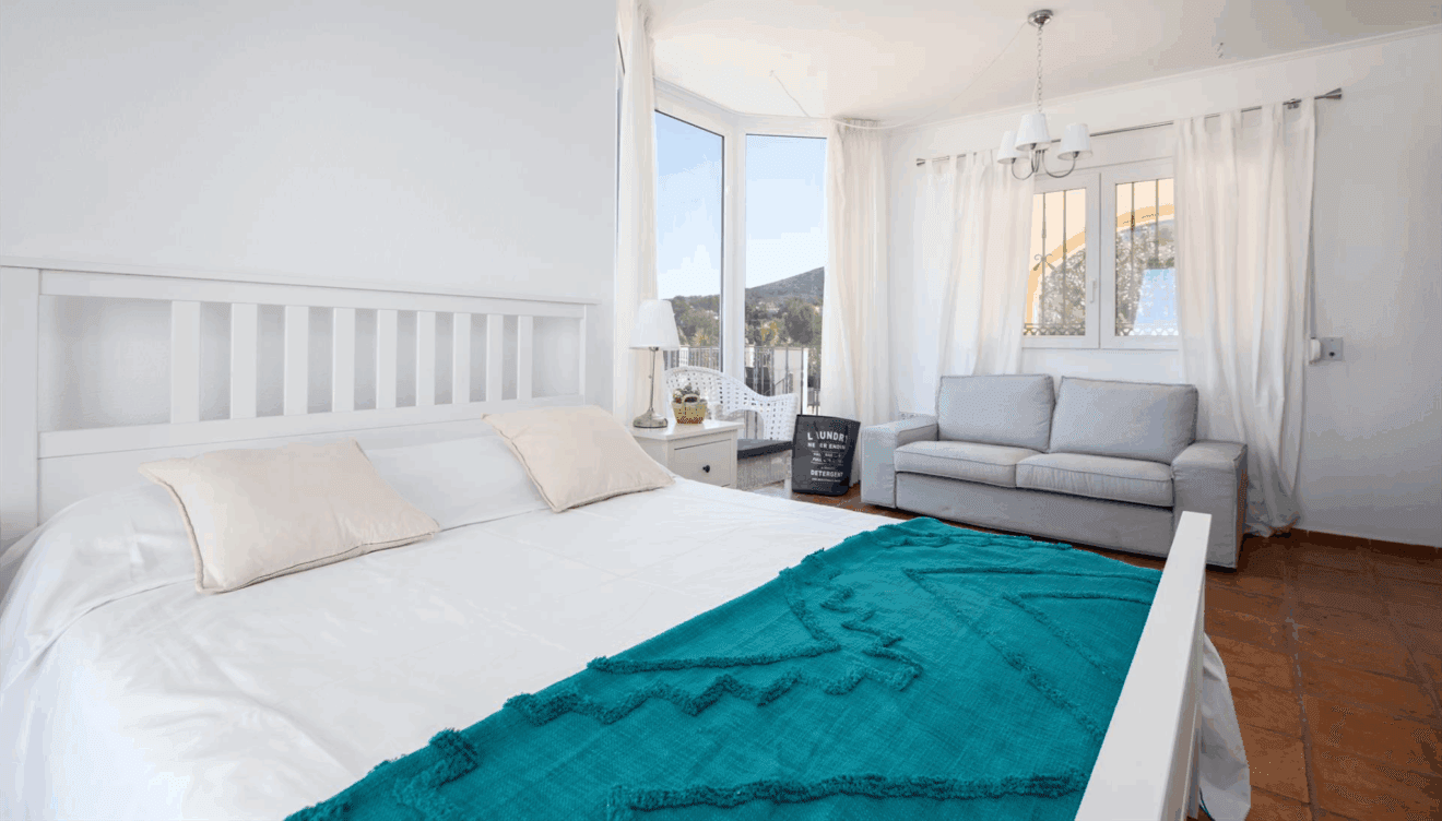 Dormitorio con cama doble, sofá y baño en suite