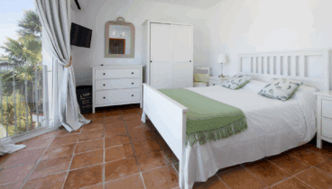 Dormitorio con cama doble y acceso directo al exterior