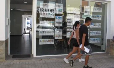 Jongeren slenteren voor een makelaarskantoor in Denia