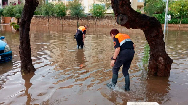 voluntarios de proteccion civil en una via anegada de denia