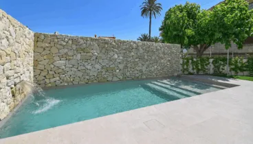 Piscina privada rodeada de jardín y tumbonas