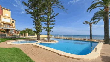Jardines con césped y árboles junto a la piscina en Casa Denimar Dénia