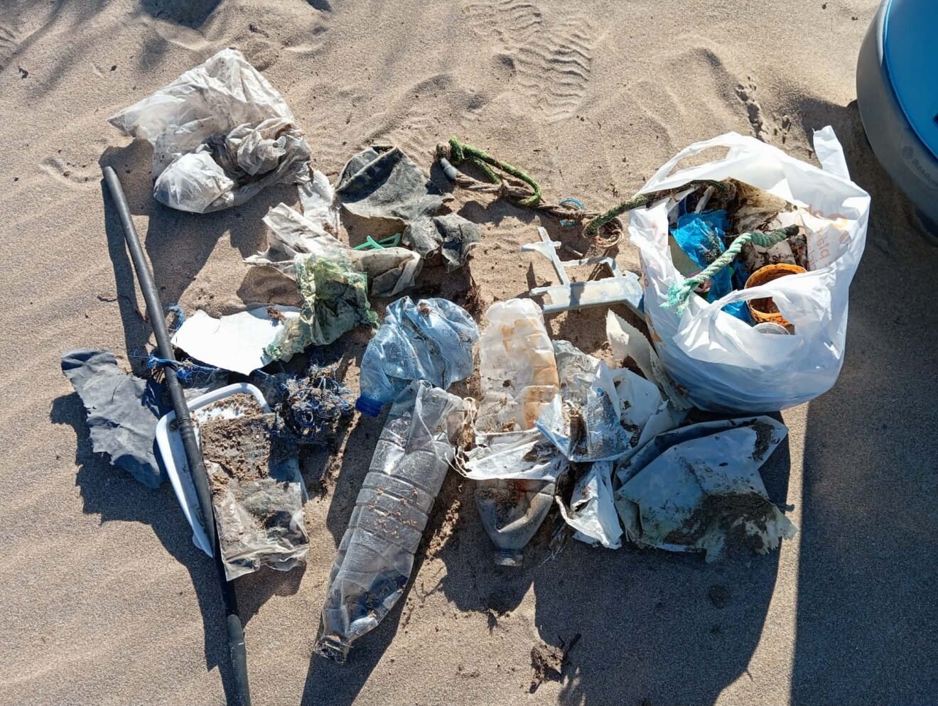 Bolsa con residuos recogidos en la arena después del temporal en Dénia