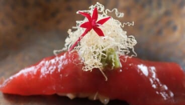 Detalle de sashimi fresco en mesa frente al mar