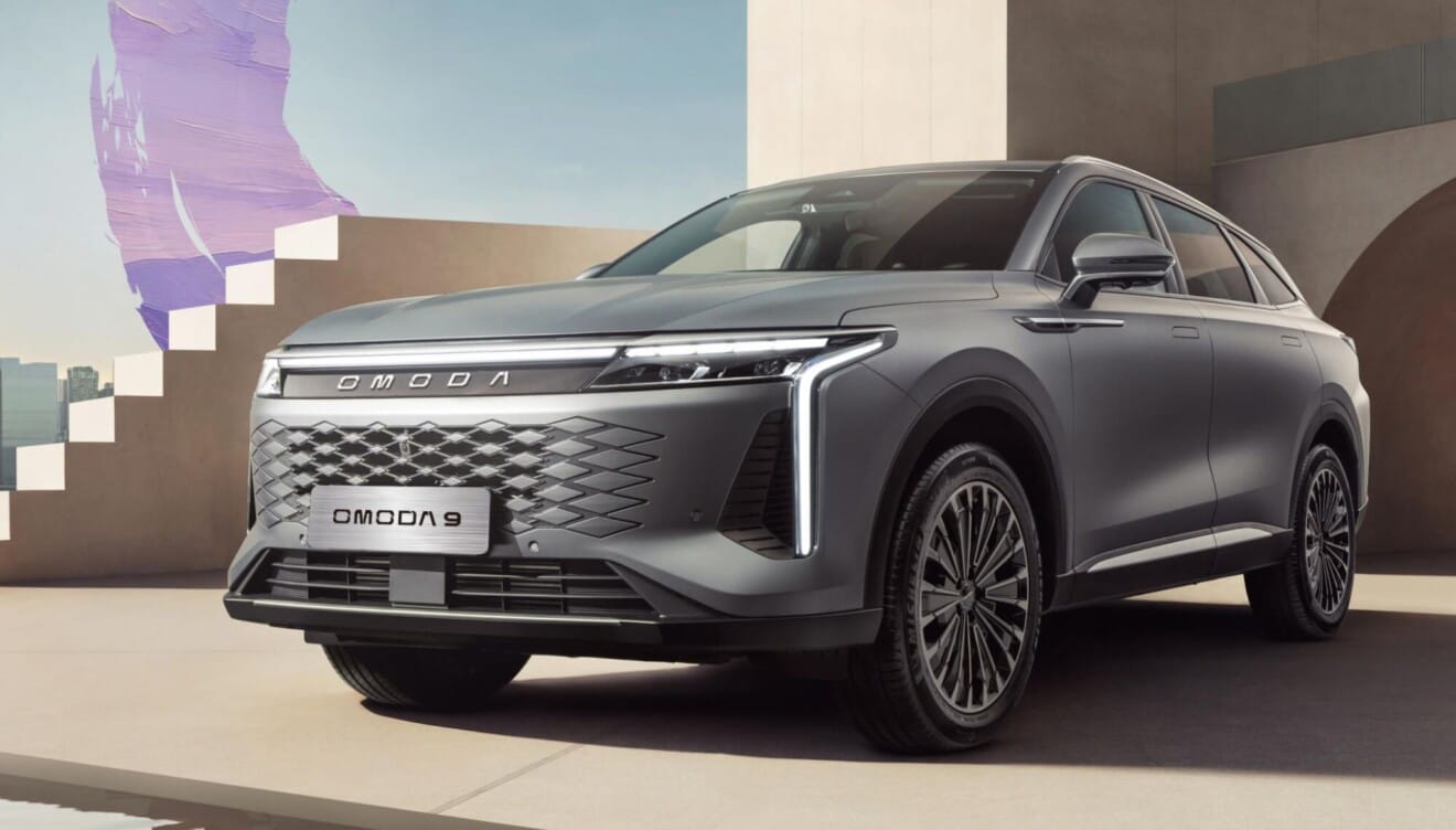 Detalle frontal y lateral del OMODA 9 SHS en carretera urbana