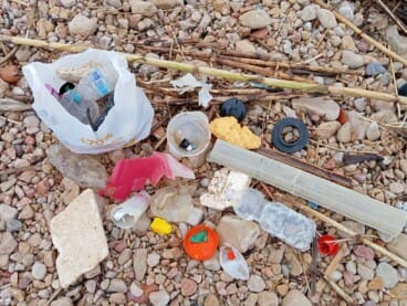 Plásticos y basura entre las piedras tras el paso del temporal en el litoral dianense