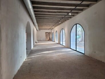 Galería interior con arcos y grandes ventanales, ya lista y a la espera del equipamiento.
