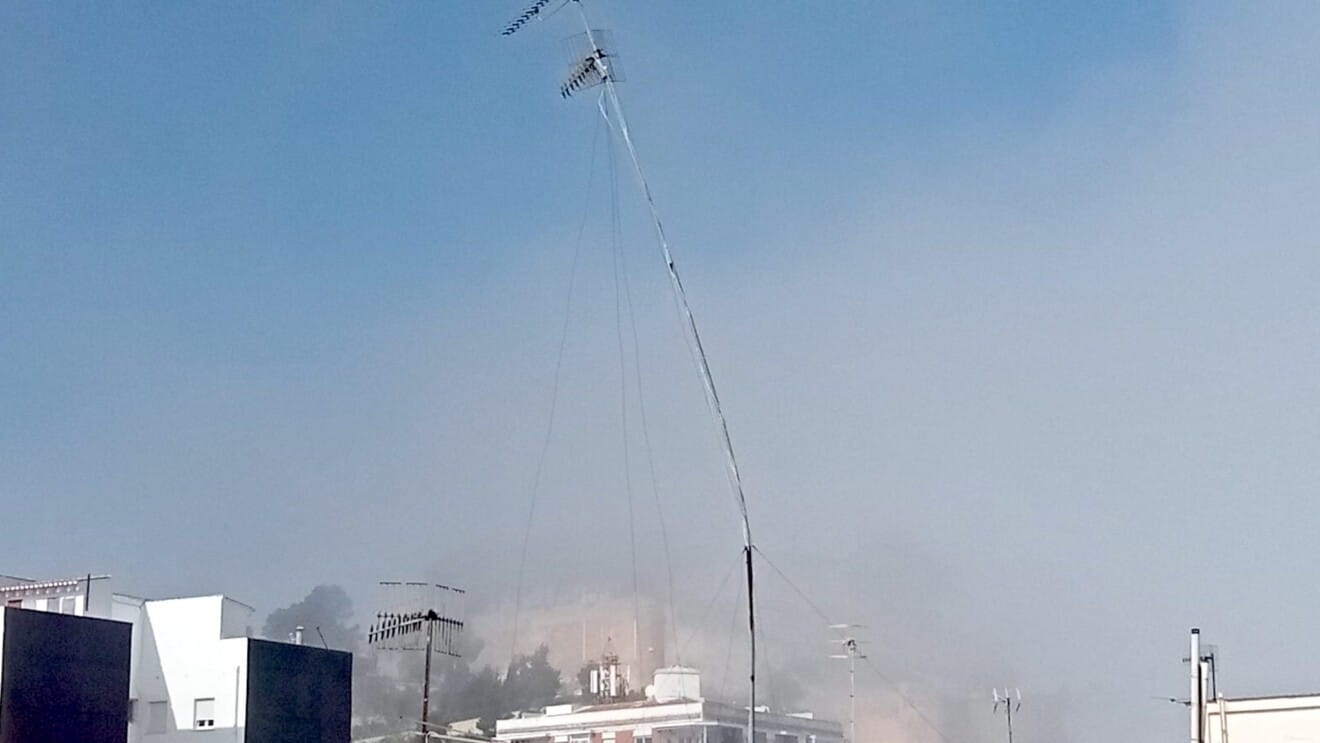 La silueta del Castillo de Dénia apenas se distingue tras las antenas del casco urbano debido a la bruma