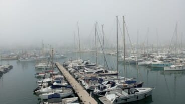 los mastiles de los veleros asomando entre la densa niebla que ha cubierto el puerto de denia hoy