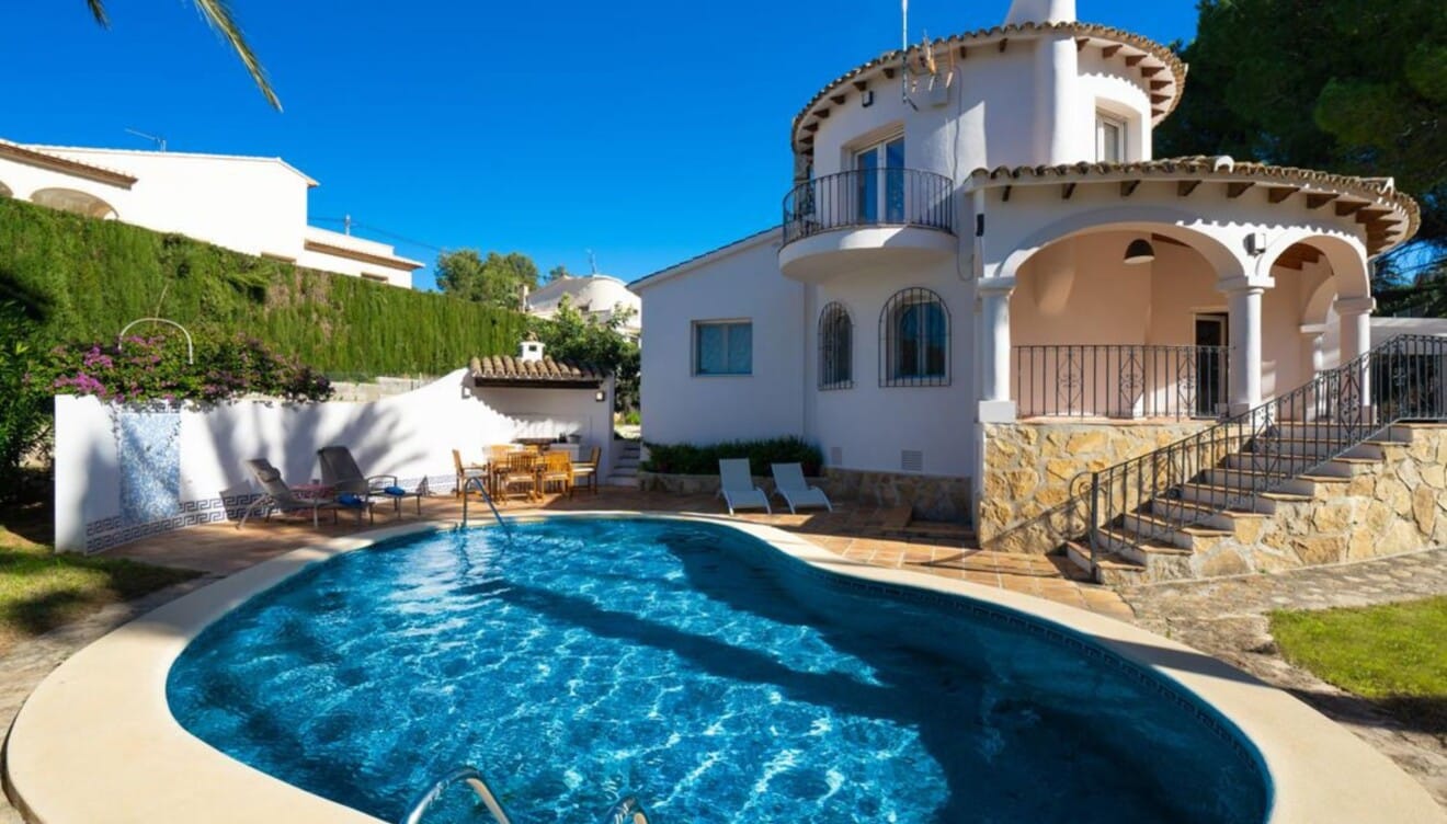 Piscina privada con forma de laguna rodeada de jardín en Denia
