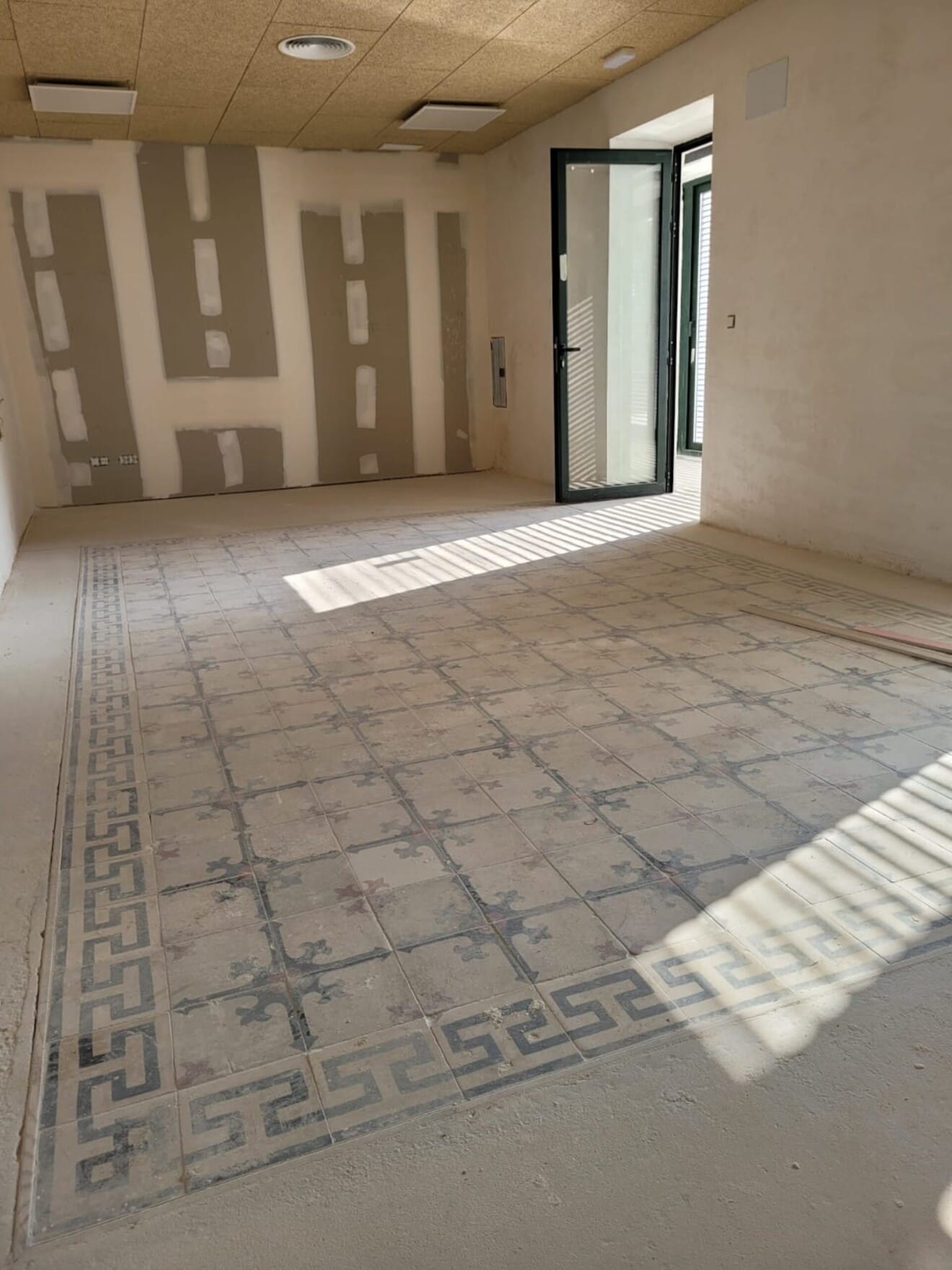 Sala con pavimento hidráulico recuperado, integrado en el nuevo espacio