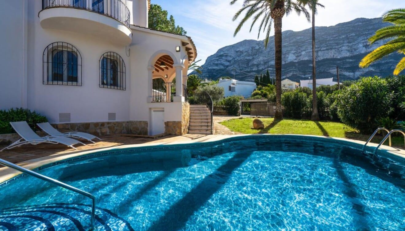 Zona de solárium con tumbonas junto a la piscina de la casa Anxao