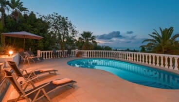 Ambiente nocturno junto a la piscina iluminada de Pool Villas