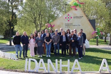 Grupo de participantes del proyecto europeo RE:START posando frente al cartel de "Idanha-a-Nova City of Music" en Portugal durante su primer encuentro.