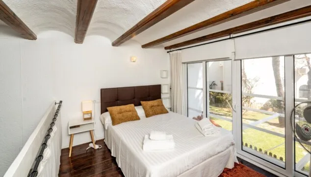 Loftartiges Schlafzimmer auf der Galerieebene mit Deckenventilator