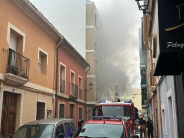 Brandweerlieden zijn bezig de brand in de Pare Pere-straat te blussen.