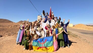 De groep was gekleed in traditionele kostuums tijdens een activiteit in de woestijn.