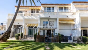 Fachada de la casa con acceso al jardín y la piscina