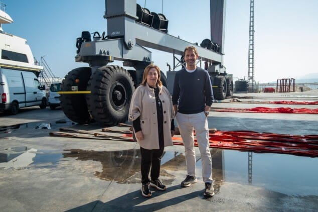 Imagen: Pepa Font y Albert Morell posan junto a maquinaria portuaria en Port Dénia Shipyard durante la visita institucional