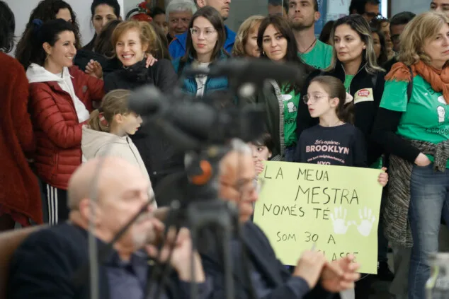 una menor sostiene una pancarta denunciando la masificacion en las aulas mi maestra solo tiene dos manos somos 30 en clase