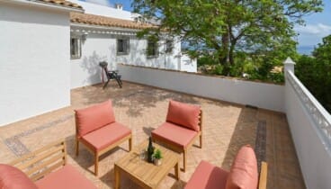 Zona de relax exterior con tumbonas rodeada de árboles