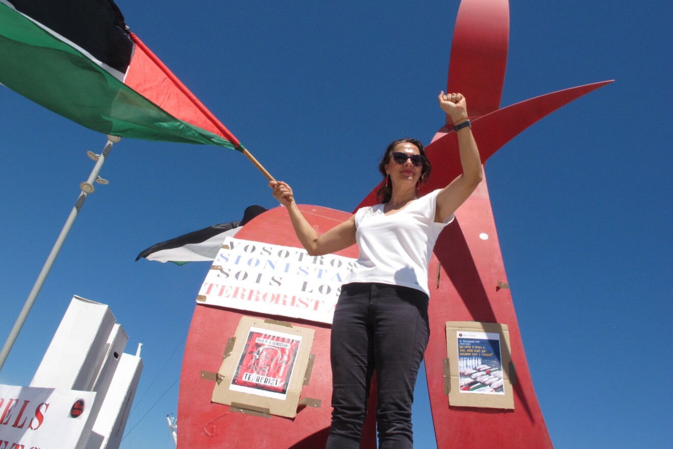 Una de las asistentes reclama el fin del conflicto bélico junto al monumento del Portal del Vent