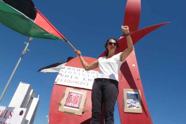 Imagen: Una de las asistentes reclama el fin del conflicto bélico junto al monumento del Portal del Vent