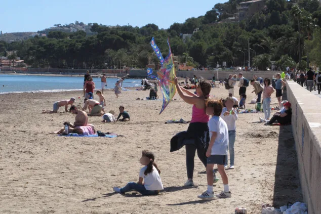 familia volando una cometa en una playa de denia