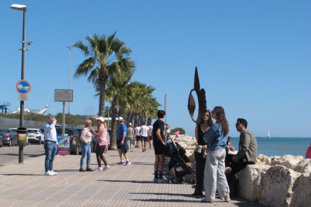 Imagen: Gran ambiente en el paseo marítimo de la ciudad, con visitantes aprovechando el sol en cada rincón disponible del litoral dianense