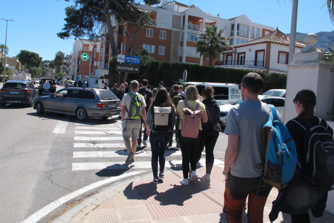 Grupos de turistas cruzando una de las vías principales de la ciudad en una jornada de máxima afluencia en el casco urbano