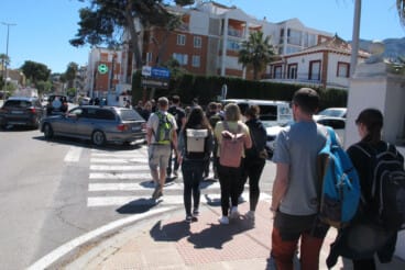 Grupos de turistas cruzando una de las vías principales de la ciudad en una jornada de máxima afluencia en el casco urbano