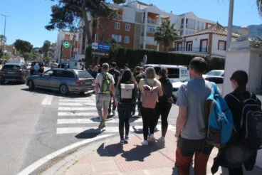 Grupos de turistas cruzando una de las vías principales de la ciudad en una jornada de máxima afluencia en el casco urbano
