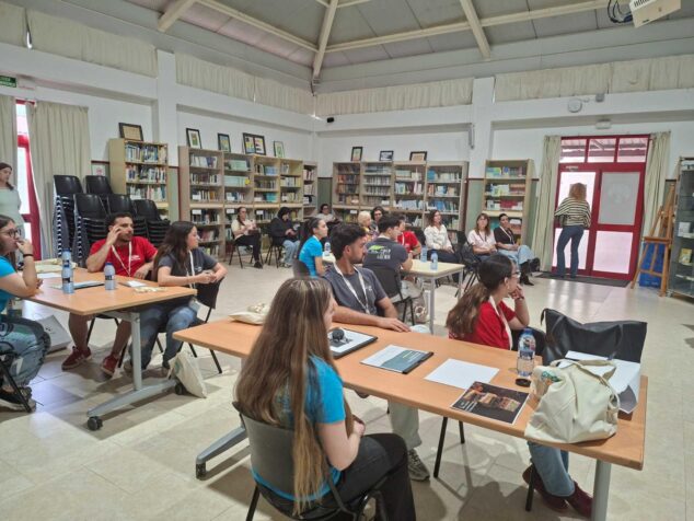 Imagen: Varios grupos de estudiantes sentados en mesas trabajando con documentos durante el I Hackathon Intercentros Marina Alta.