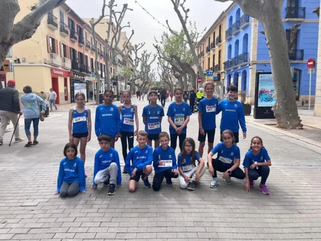 Grupo de jóvenes atletas del Club de Atletismo Baleària Diànium posando juntos en una calle de Dénia.