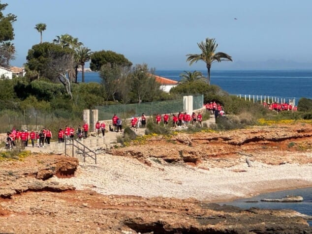 Imagen: La extensa hilera de participantes recorriendo el sendero litoral de Les Rotes, una imagen que refleja el éxito de convocatoria de Amunt contra el càncer en este 2026