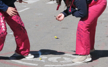 ninas encendiendo un petardo durante la planta de las fallas de denia