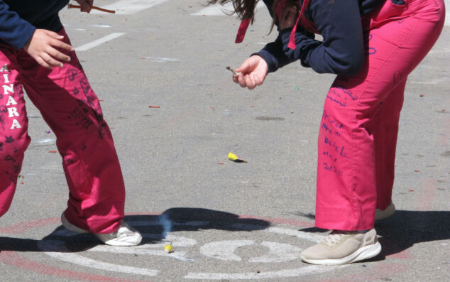 Imagen: Niñas encendiendo un petardo durante la plantà de las Fallas de Dénia