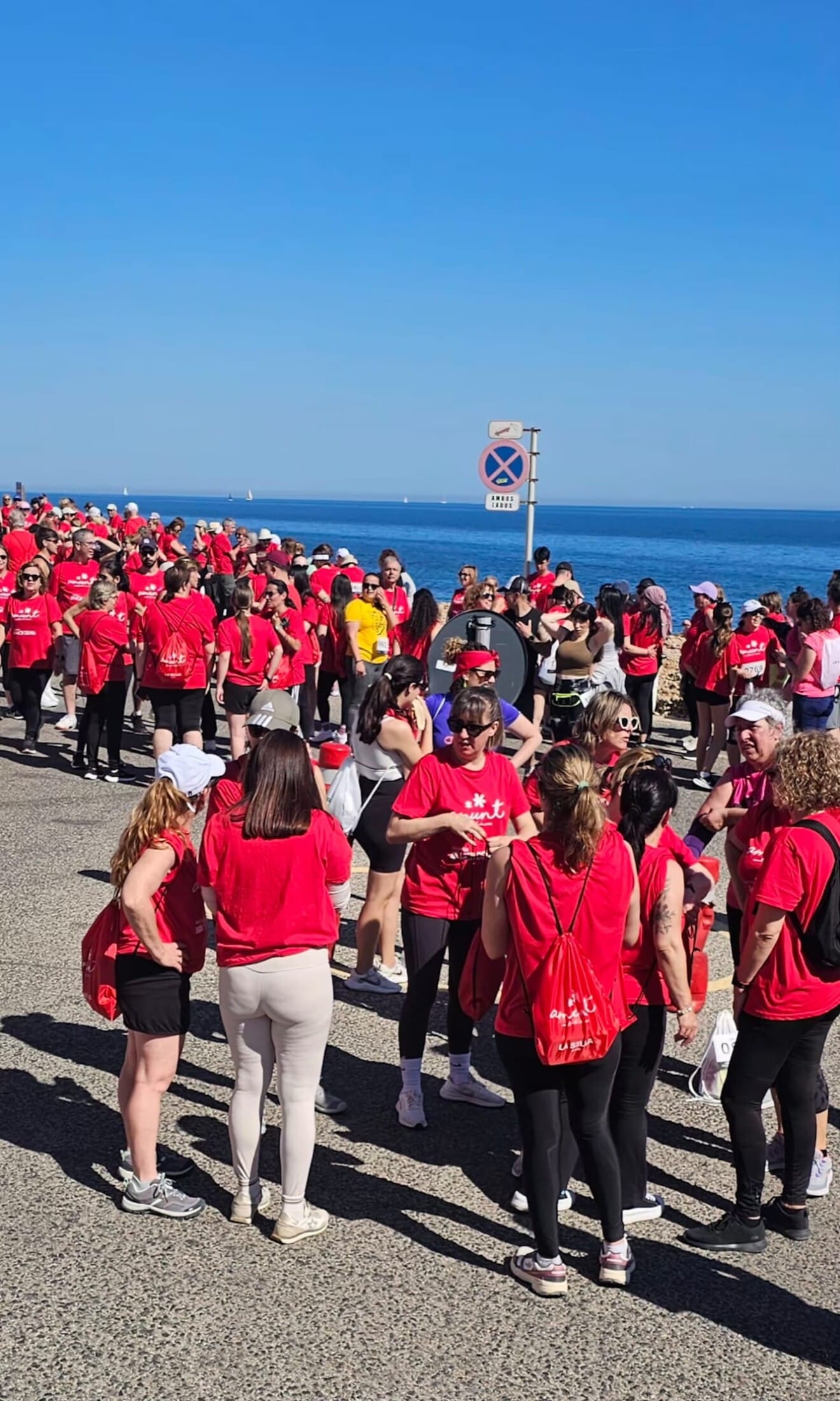 Participantes de la caminata solidaria celebrando el éxito de la convocatoria en la meta, ubicada al final de Les Rotes, tras completar un recorrido que este año ha batido récords de participación