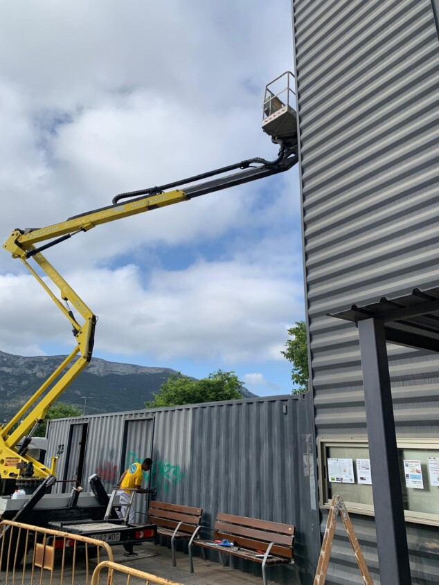 Imagen: Un operario realiza tareas de repintado en la parte superior de la estructura vertical de la estación de autobuses de Dénia
