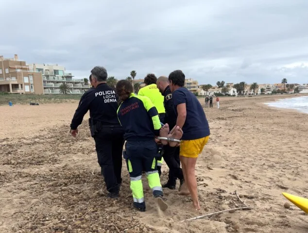 Dramático rescate en Dénia: un policía y un bombero salvan a un bañista ebrio a 300 metros de la costa 3 Imagen: Agentes y personal sanitario trasladan al bañista rescatado a una zona segura de la playa