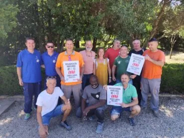 Grupo de trabajadores y sindicalistas sosteniendo carteles que exigen la reclasificación profesional de AP a C2.