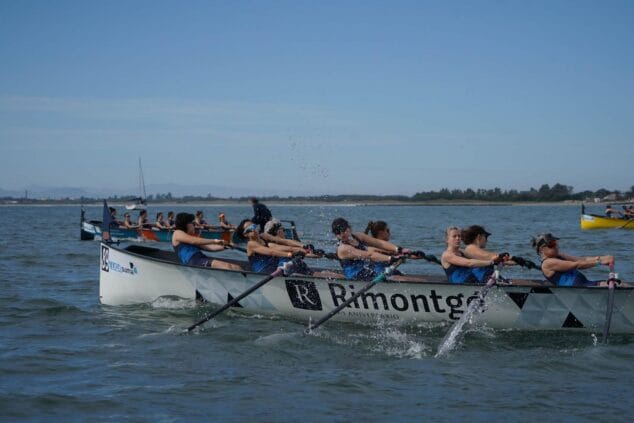 Equipo femenino de remo compitiendo en una embarcación de Llaüt Mediterráneo en el mar.