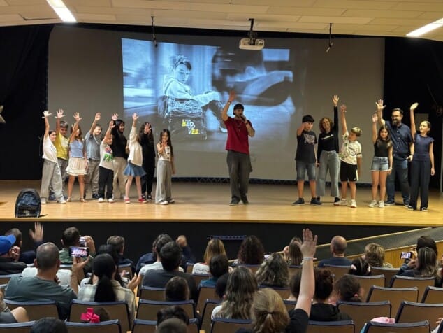 «Cerrad los ojos y levantad la mano si habéis sufrido acoso»: el momento que cambió el proyecto contra el bullying en Dénia 1 Imagen: El salón de actos de Dénia se une al gesto del videoclip: familias y alumnos levantan la mano para romper el silencio frente al bullying