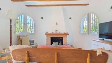 Salón mediterráneo con chimenea en El Montgó