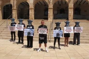 arkano y los activistas de peta con mascaras de toro frente al consistorio de denia