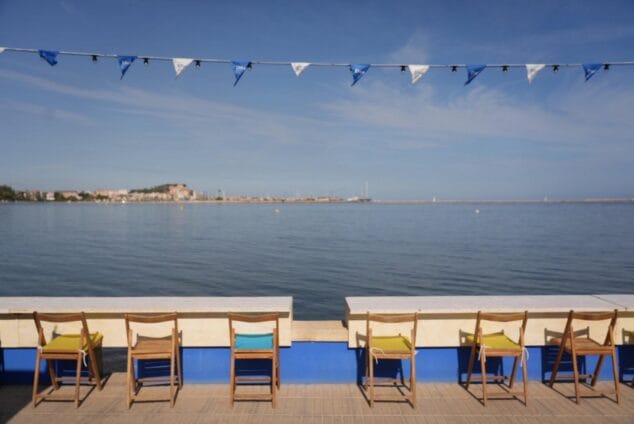 Quique Dacosta vuelve a comisariar el próximo D*na Festival, que ya tiene fecha y temática: los libros 2 Imagen: Paseo marítimo de Dénia con sillas y banderas del D*na Festival frente al mar.